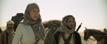 Movie still from “Queen of the Desert” (2015), directed by Werner Herzog – A man and a woman are standing in the desert; Medium shot, Over the shoulder angle