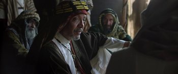 Movie still from “Queen of the Desert” (2015), directed by Werner Herzog – Two men in traditional clothing sitting next to each other; Close Up shot, Over the shoulder angle