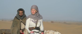 Movie still from “Queen of the Desert” (2015), directed by Werner Herzog – A woman in a headscarf is sitting on a horse; Medium shot, Low angle
