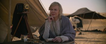 Movie still from “Queen of the Desert” (2015), directed by Werner Herzog – A woman sitting at a table holding a pen; Close Up shot, Over the shoulder angle