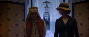 Movie still from “Queen of the Desert” (2015), directed by Werner Herzog – A man and a woman wearing hats in an archway; Medium shot, Over the shoulder angle