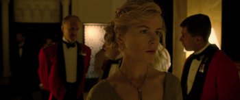 Movie still from “Queen of the Desert” (2015), directed by Werner Herzog – A woman with blonde curly hair wearing a necklace; Close Up shot, Over the shoulder angle