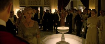 Movie still from “Queen of the Desert” (2015), directed by Werner Herzog – A group of people standing around a fountain; Medium shot, Over the shoulder angle