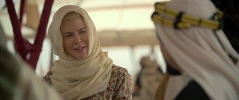 Movie still from “Queen of the Desert” (2015), directed by Werner Herzog – A woman wearing a head scarf and a floral dress; Close Up shot, Over the shoulder angle