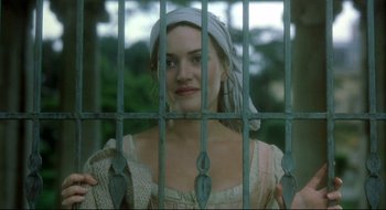 Movie still from “Quills” (2000), directed by Philip Kaufman – A woman with a head scarf standing behind a fence; Close Up shot, Over the shoulder angle