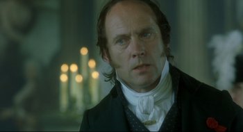 Movie still from “Quills” (2000), directed by Philip Kaufman – A person wearing a suit and tie; Close Up shot, Over the shoulder angle