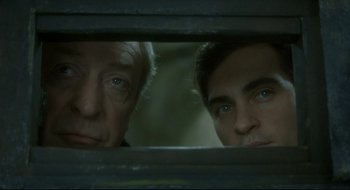 Movie still from “Quills” (2000), directed by Philip Kaufman – Two men looking through a window at each other; Close Up shot, Low angle