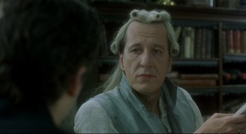 Movie still from “Quills” (2000), directed by Philip Kaufman – A man with long white hair is looking at the camera; Close Up shot, Over the shoulder angle