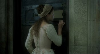 Movie still from “Quills” (2000), directed by Philip Kaufman – A woman wearing a corset and a long skirt; Medium shot, Over the shoulder angle