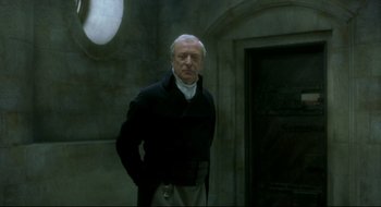 Movie still from “Quills” (2000), directed by Philip Kaufman – An older man standing in front of a building; Medium shot, Low angle