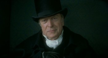 Movie still from “Quills” (2000), directed by Philip Kaufman – An older man wearing a top hat and a black coat; Close Up shot, Low angle