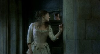 Movie still from “Quills” (2000), directed by Philip Kaufman – A woman in a white dress looking into a mirror; Medium shot, Over the shoulder angle
