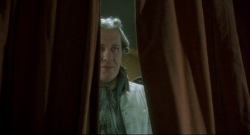 Movie still from “Quills” (2000), directed by Philip Kaufman – A man in a wig looking at himself in a mirror; Close Up shot, Low angle