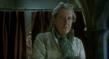 Movie still from “Quills” (2000), directed by Philip Kaufman – An older man in a white coat and a green scarf; Close Up shot, Over the shoulder angle
