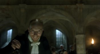 Movie still from “Quills” (2000), directed by Philip Kaufman – A man with a beard is smiling for the camera; Close Up shot, Low angle