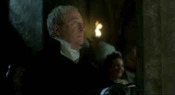 Movie still from “Quills” (2000), directed by Philip Kaufman – An older man sitting in front of an audience; Medium shot, Low angle