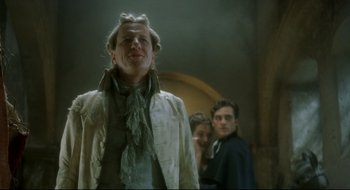 Movie still from “Quills” (2000), directed by Philip Kaufman – A group of people standing next to each other in a room; Medium shot, Low angle