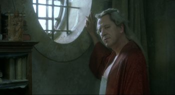 Movie still from “Quills” (2000), directed by Philip Kaufman – A man wearing a robe leaning against a wall; Medium shot, Low angle