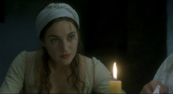 Movie still from “Quills” (2000), directed by Philip Kaufman – A young woman sitting in front of a lit candle; Close Up shot, Over the shoulder angle
