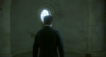 Movie still from “Quills” (2000), directed by Philip Kaufman – A man standing in front of a round window; Medium shot, Low angle