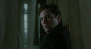 Movie still from “Quills” (2000), directed by Philip Kaufman – A person wearing a suit and tie; Close Up shot, Low angle