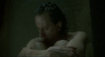 Movie still from “Quills” (2000), directed by Philip Kaufman – A man with long black hair is sitting in a bath tub; Close Up shot, High angle