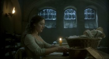 Movie still from “Quills” (2000), directed by Philip Kaufman – A woman sitting at a table with a lit candle; Medium shot, Low angle