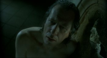 Movie still from “Quills” (2000), directed by Philip Kaufman – A man with long hair is laying on the ground; Close Up shot, High angle