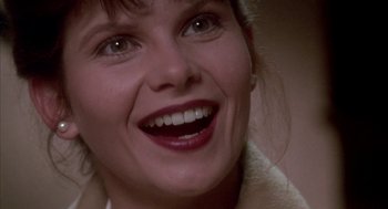 Movie still from “Raising Cain” (1992), directed by Brian De Palma – A woman's face with white teeth; Close Up shot, Low angle