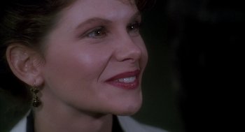 Movie still from “Raising Cain” (1992), directed by Brian De Palma – A woman's face with a smile; Close Up shot, Over the shoulder angle