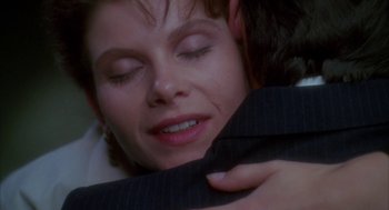 Movie still from “Raising Cain” (1992), directed by Brian De Palma – A person wearing a suit jacket; Close Up shot, Over the shoulder angle