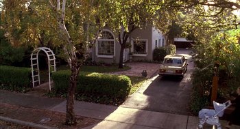Movie still from “Raising Cain” (1992), directed by Brian De Palma – A car is parked on the side of the street; Extreme Wide shot, High angle