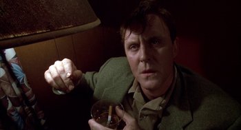 Movie still from “Raising Cain” (1992), directed by Brian De Palma – A man holding a cigarette and a glass of alcohol; Close Up shot, Low angle