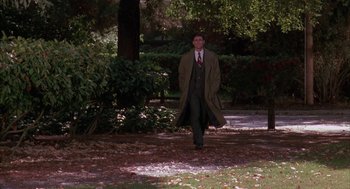 Movie still from “Raising Cain” (1992), directed by Brian De Palma – A man in a suit and tie walking in a park; Wide shot, High angle