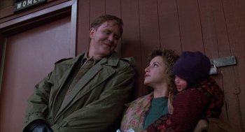Movie still from “Raising Cain” (1992), directed by Brian De Palma – A man and a woman sitting next to a child; Medium shot, Low angle