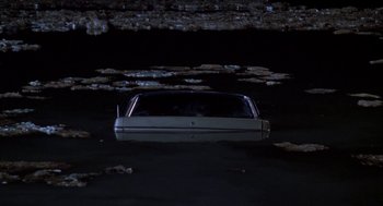 Movie still from “Raising Cain” (1992), directed by Brian De Palma – A car that is sitting in the middle of a lake; Extreme Wide shot, High angle
