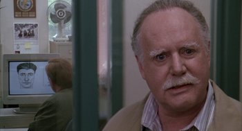 Movie still from “Raising Cain” (1992), directed by Brian De Palma – An older man with a mustache looking at the camera; Close Up shot, Over the shoulder angle