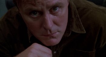 Movie still from “Raising Cain” (1992), directed by Brian De Palma – A person with his hand on his chin; Close Up shot, Low angle