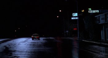 Movie still from “Raising Cain” (1992), directed by Brian De Palma – A car driving down a street at night; Extreme Wide shot, Low angle