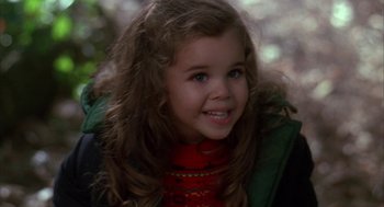 Movie still from “Raising Cain” (1992), directed by Brian De Palma – A little girl with long brown hair wearing a green jacket; Close Up shot, High angle