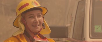 Movie still from “Rams” (2020), directed by Jeremy Sims – A woman wearing a yellow hat and holding a cup; Close Up shot, Over the shoulder angle