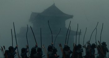 Movie still from “Ran” (1985), directed by Akira Kurosawa – A group of people with bow and arrows in the fog; Extreme Wide shot, Low angle