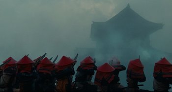 Movie still from “Ran” (1985), directed by Akira Kurosawa – A group of people with red hats are standing in the fog; Extreme Wide shot, Low angle