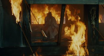 Movie still from “Ran” (1985), directed by Akira Kurosawa – A person sitting in front of a fire; Wide shot, High angle