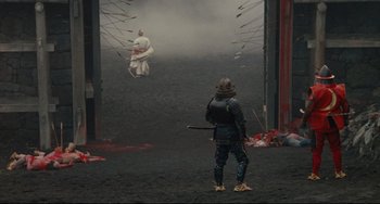Movie still from “Ran” (1985), directed by Akira Kurosawa – A man in a samurai outfit standing in front of a man in a samurai outfit; Extreme Wide shot, High angle