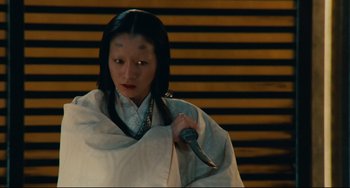 Movie still from “Ran” (1985), directed by Akira Kurosawa – A person holding a knife in their hand; Close Up shot, High angle