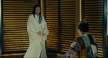 Movie still from “Ran” (1985), directed by Akira Kurosawa – A woman in a white robe standing next to another woman; Medium shot, Over the shoulder angle