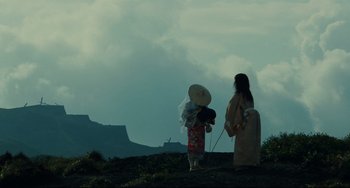 Movie still from “Ran” (1985), directed by Akira Kurosawa – Two women are standing on a hill looking out at the sky; Extreme Wide shot, Low angle