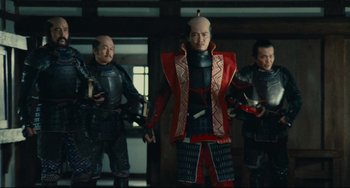 Movie still from “Ran” (1985), directed by Akira Kurosawa – A group of men standing next to each other in a room; Medium shot, Low angle