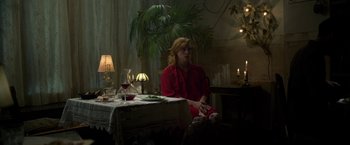 Movie still from “Rare Beasts” (2019), directed by Billie Piper – A woman sitting at a table with a glass of red wine; Medium shot, Over the shoulder angle